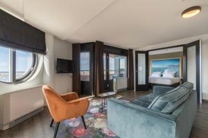 a living room with a couch and a bed at Leonardo Hotel IJmuiden Seaport Beach in IJmuiden