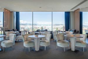 a restaurant with tables and chairs and large windows at Leonardo Royal Hotel Barcelona Forum in Barcelona +72 photos