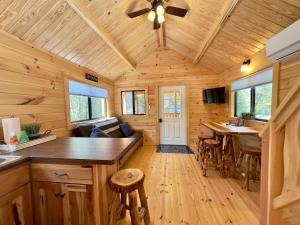 a kitchen and living room of a log cabin at Cozy Coastal Cabin 3 in Steuben
