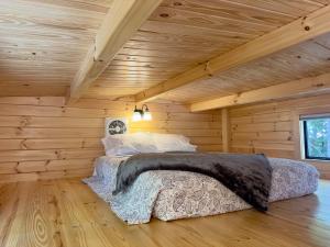 a bedroom with a bed in a log cabin at Cozy Coastal Cabin 3 in Steuben