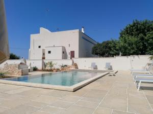 a swimming pool in front of a white building at Civico57 Torre Suda in Torre Suda