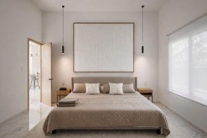 a bedroom with a large bed and a framed picture at Nomad Luxe Tulum in Tulum