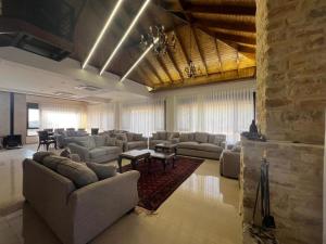 a large living room with couches and tables in it at Bait Ajloun in Khirbat Shīn