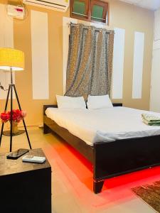 a bedroom with a bed and a table with a lamp at Debox heaven Homestay in Jorhat