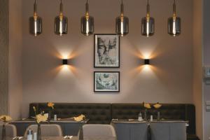a dining room with tables and lights on the wall at Leonardo Hotel Heidelberg City Center in Heidelberg +21 photos