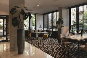 a living room with a couch and a table and plants at Leonardo Hotel Heidelberg City Center in Heidelberg