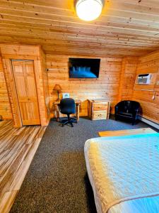 a bedroom with a bed and a desk and a television at Alpine Lodge in Red Lodge