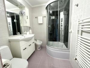 a bathroom with a sink and a shower and a toilet at Max Apartment in Ocna-Mureşului
