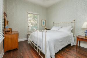 a bedroom with a white bed and a window at Inn On The River in Glen Rose