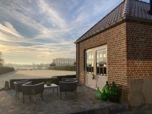 a patio with chairs and a table and a building at Maison Lion Luxe gastenverblijf in Borgloon +37 photos