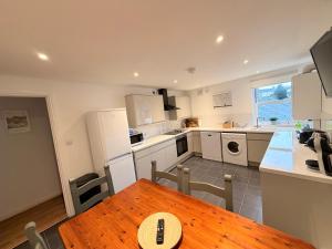 a kitchen with a wooden table and a dining room at Low Haven in Keswick