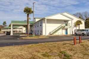 a building with a car parked in a parking lot at Plantation Inn & Suites Near Locust Grove I 75 in Jackson
