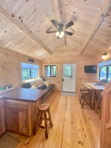 a log cabin with a kitchen and a ceiling fan at Cozy Coastal Cabin 4 in Steuben
