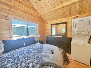 a bedroom with a bed and a television in a cabin at Cozy Coastal Cabin 4 in Steuben