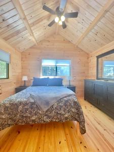 a bedroom with a bed and a ceiling fan at Cozy Coastal Cabin 4 in Steuben