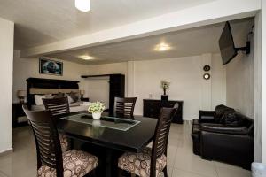 a living room with a table and chairs and a bedroom at HOTEL LAS FUENTES in Tepotzotlán