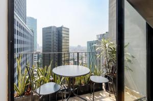 a balcony with a table and chairs and a city at Casa Colón by Wynwood House in Mexico City