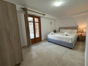 a bedroom with a bed and a large window at Evdilos blue serenity by BRP-PROPERTIES in Evdilos