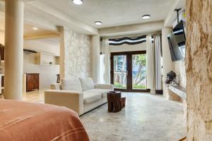 a living room with a couch and a tv at Alquimia Hotel Boutique in Tulum
