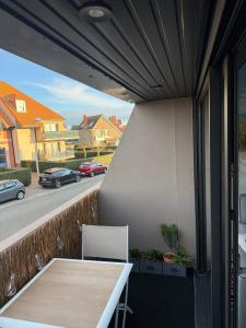 a balcony with a table and a view of a street at L'effet Dune in Sangatte