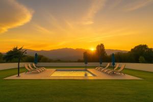 a group of chairs with umbrellas and a pool at Campo Vecchio Dracena et Piscine in Ghisonaccia