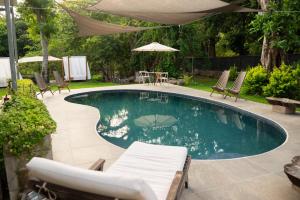 a swimming pool with chairs and a table and an umbrella at Amalfi Surf Lodge in ChiltiupÃ¡n