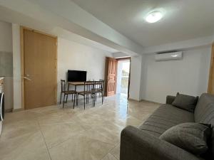 a living room with a couch and a table with chairs at Evdilos blue serenity by BRP-PROPERTIES in Evdilos