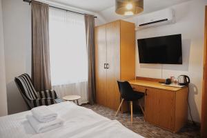 a hotel room with a bed and a desk and a television at Penzion Kastiel in Veľký Krtíš