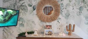 a table with a television and a mirror on a wall at La Maisonnette in Calais