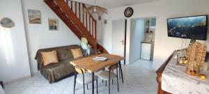 a living room with a table and a couch at La Maisonnette in Calais