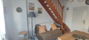 a living room with a couch and a staircase at La Maisonnette in Calais