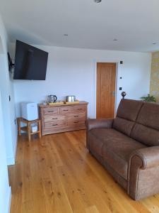 a living room with a couch and a wooden floor at Room with a View in Glastonbury