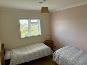 a bedroom with two beds and a window at Leagarth House in Baltasound