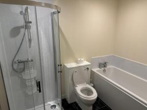a bathroom with a shower and a toilet and a bath tub at Leagarth House in Baltasound +4 photos