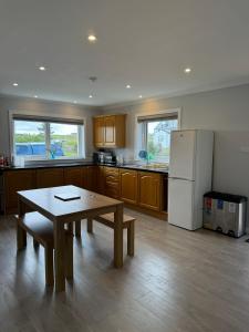 a kitchen with a table and a refrigerator at Leagarth House in Baltasound