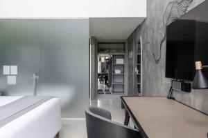 a bedroom with a bed and a desk with a television at Suryaa Hotel Pinhais, Curio Collection by Hilton in Pinhais +47 photos