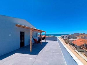 a patio with a hammock on the roof of a house at Rooftop BeiraMar in Balneario Barra do Sul +4 photos
