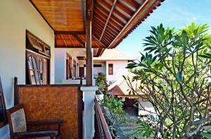 a balcony with a view of a house at Yulia 2 Homestay Sanur in Sanur