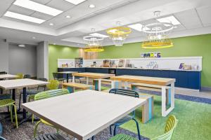 a cafeteria with tables and chairs and a counter at Spark by Hilton Macon North in Macon