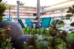 a group of chairs and a table in front of a building at HOTEL LAS FUENTES in Tepotzotlán
