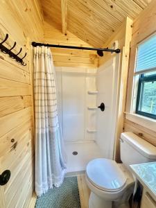 a small bathroom with a toilet and a shower at Cozy Coastal Cabin 5 in Steuben +24 photos