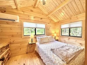 a bedroom with a bed in a wooden cabin at Cozy Coastal Cabin 5 in Steuben