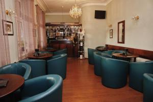 a dining room with blue chairs and a bar at Penzion Kastiel in Veľký Krtíš +23 photos