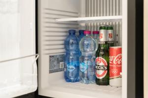 a refrigerator filled with bottles of water and soda at Baires Guest House 2 in Milan