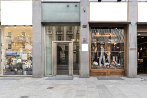 a store front with its doors open on a city street at Baires Guest House 2 in Milan