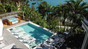 an overhead view of a swimming pool with lounge chairs and a swimming pool at Catalina Hotel in Ubatuba