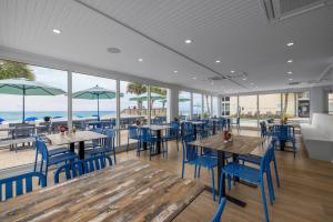 a restaurant with tables and chairs and a view of the ocean at Oceanfront Litchfield Inn in Pawleys Island