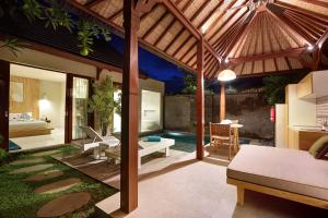 an outdoor patio with a pool and a wooden pergola at Theanna Villa and Spa Canggu in Canggu
