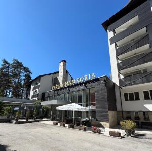 a building with an umbrella in front of it at SPA Apartment Alex in Borovets