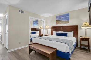 a bedroom with a large bed with blue pillows at Summer Sands - 304 by Sea Scape Properties in Wrightsville Beach